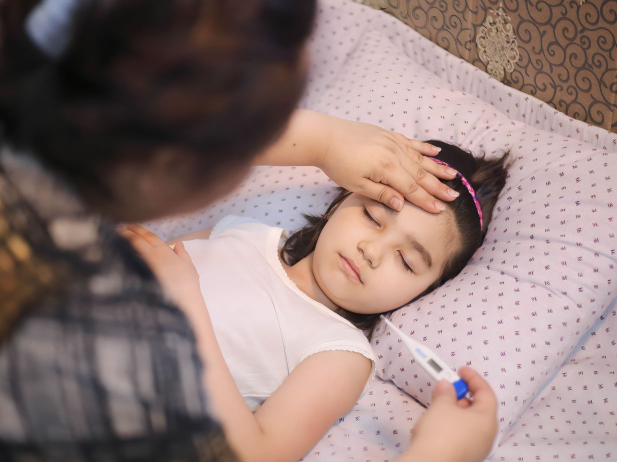 Madre tomando la temperatura a su hija, con un termómetro