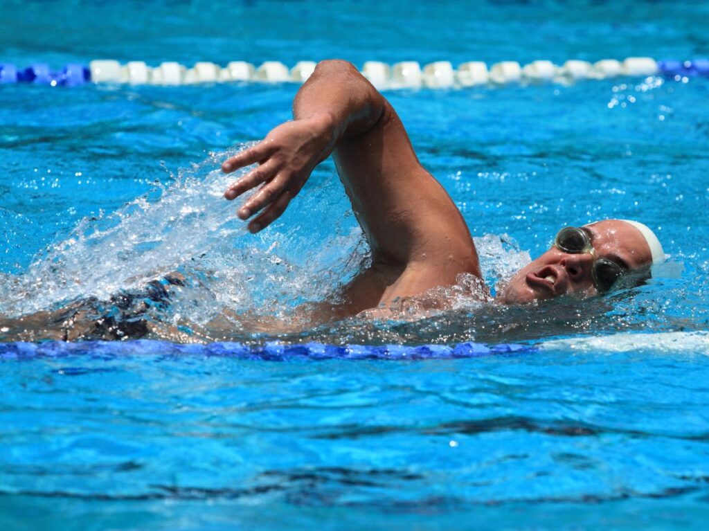 Persona practicando estilos de natación con sus reglas, nadando de crol