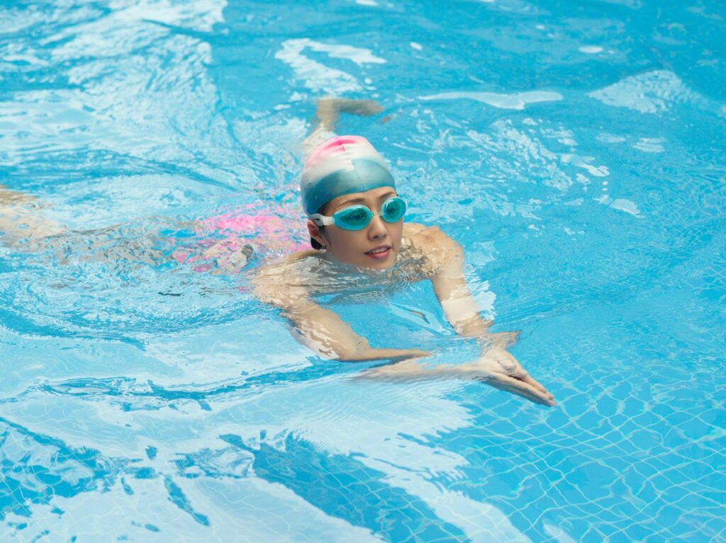 Mujer aprendiendo estilos de natación con sus reglas, nadando de pecho