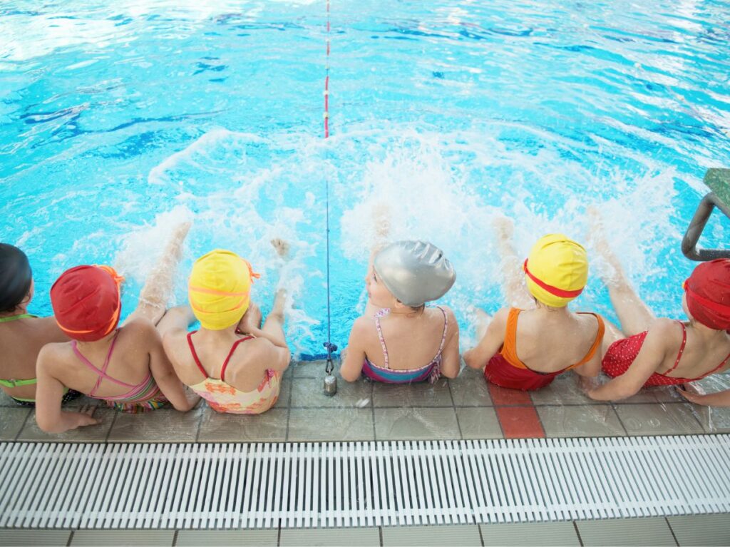 Niños nadando y aprendiendo una de las habilidades para niño que son básicas 