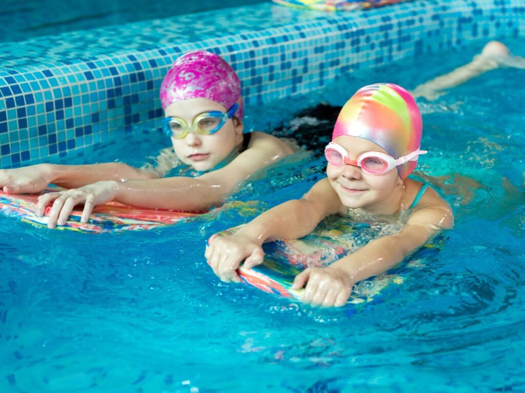 Dos niños aprendiendo a nadar